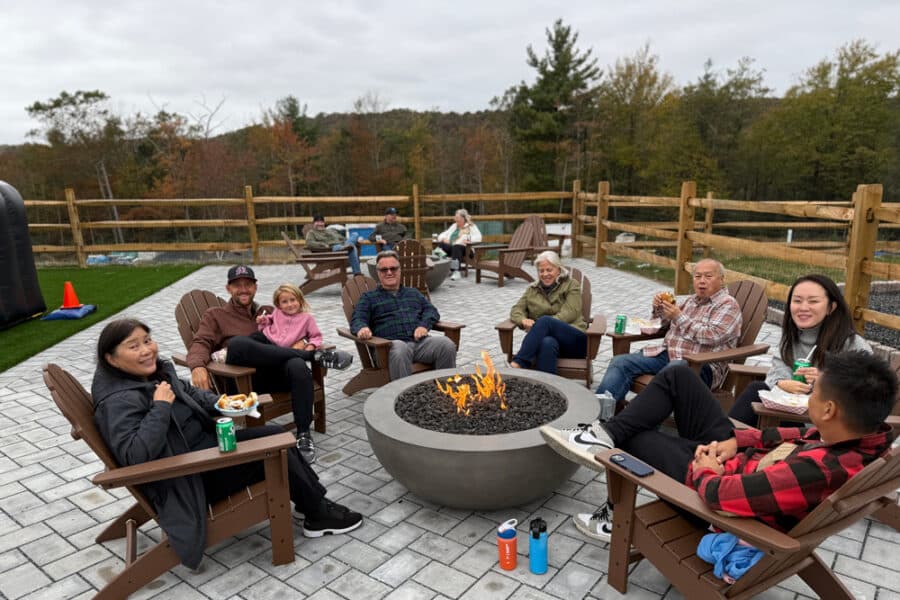 A group of members enjoying the fire pit on the great lawn